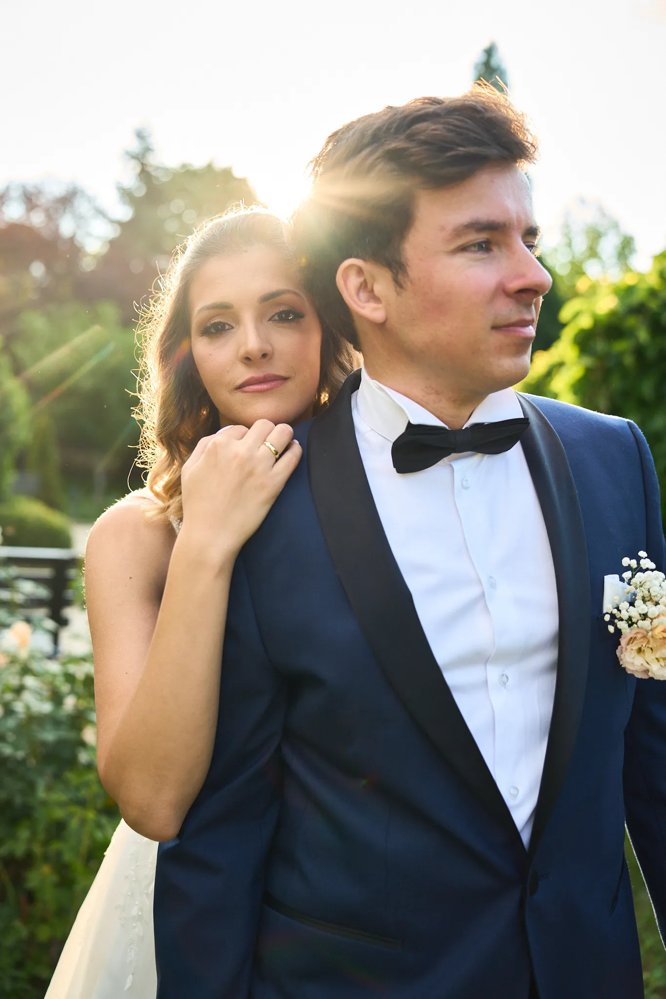Bride resting her hand on the groom's shoulder in golden evening light