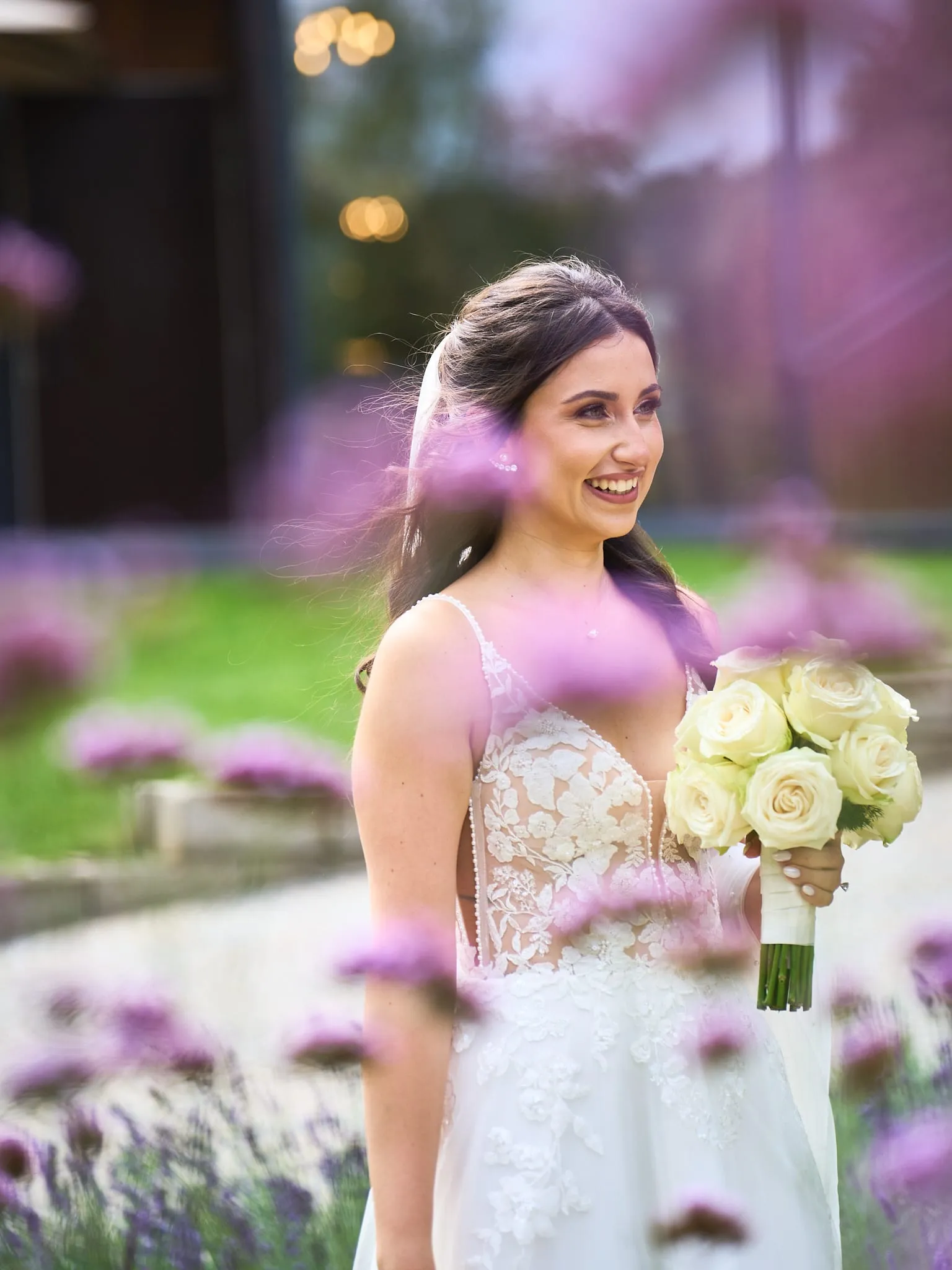Bride laughing among purple flowers in the garden
