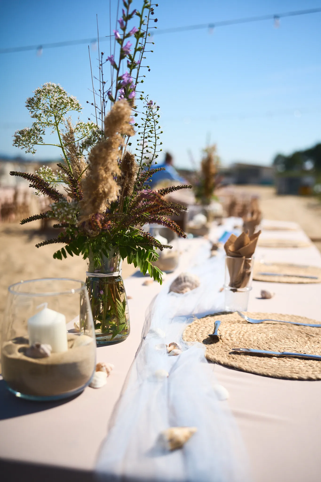 Beach table decorated with wildflowers and candles